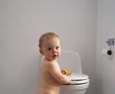 toddler standing by toilet learning how to start potty training