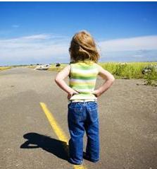 child standing in street displaying symptoms of mild autism