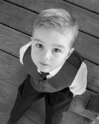 Little boy with asperger syndrome behavior in suit looking up at camera