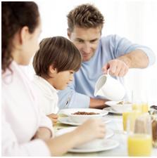 Parents giving child breakfast as part of an autism diet plan