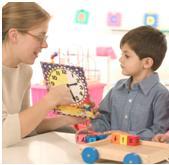 Teacher applying autism treatment techniques to child using clock