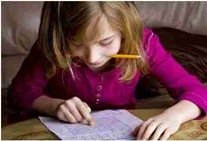 child with attention and memory problems looking at paper with pencil in hand displaying good study tips
