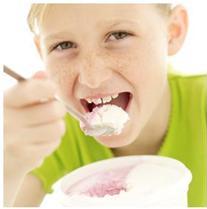 A child taking a bite of food with symptoms of oral defensiveness and dysfunction