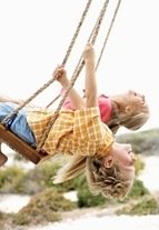 children swinging with their heads upside down displaying a symptom of a sensory processing disorder
