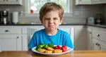 boy making face with food in front of him being picky eater